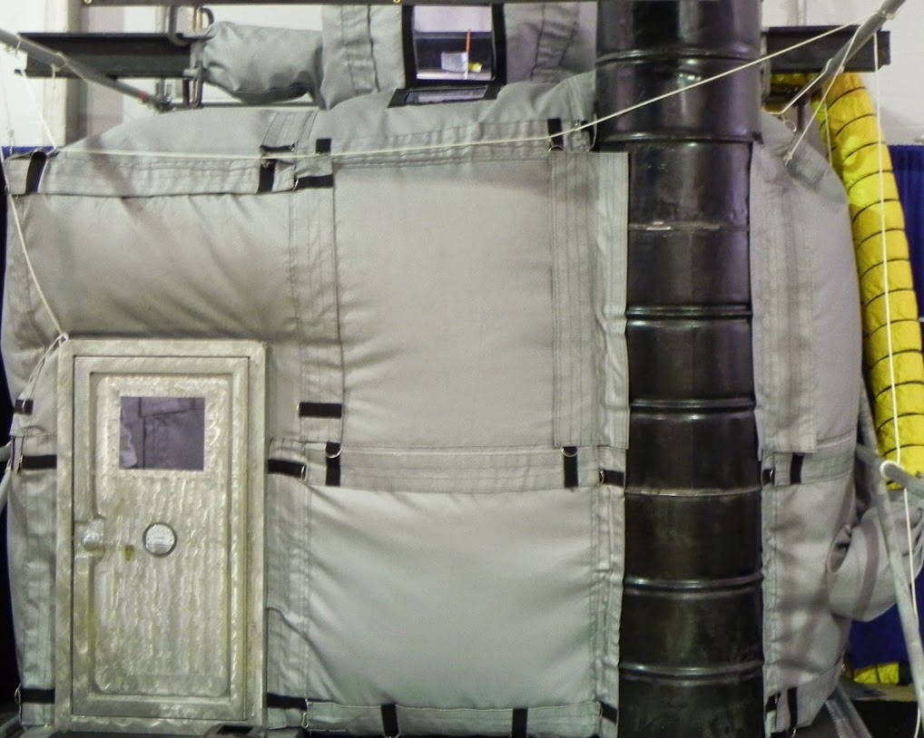 Insulated industrial door with padded wall panels and ductwork.