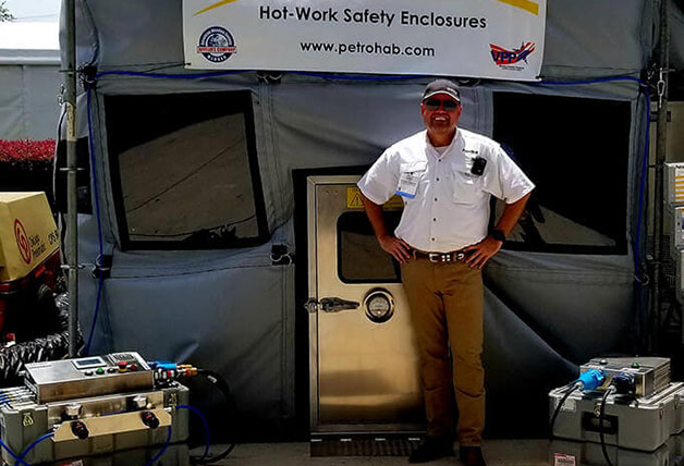 Man standing beside a portable hot work safety enclosure.