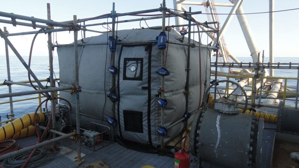 A large industrial tank wrapped in insulation and surrounded by scaffolding.